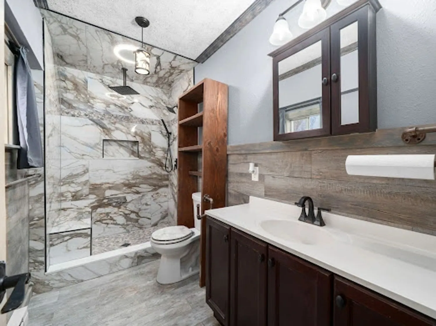 Custom tile shower with marble-look large-format tile and dark vanity