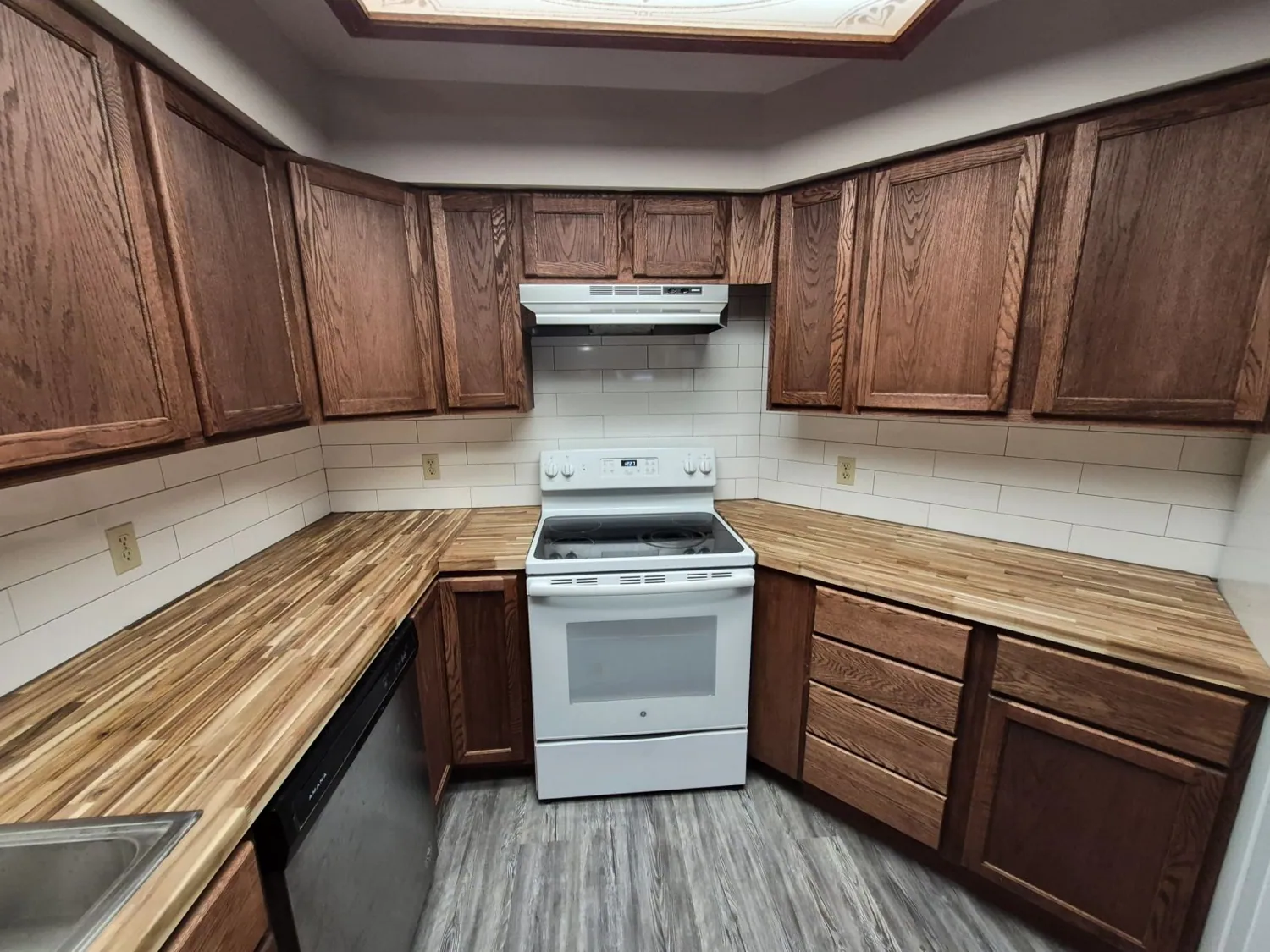 Stained kitchen cabinets, butcher-block counters and white range