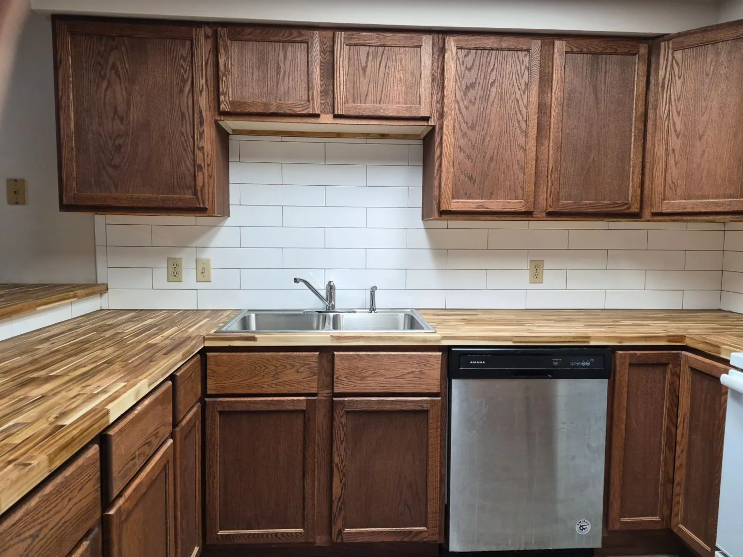 Butcher-block countertop with white subway tile backsplash