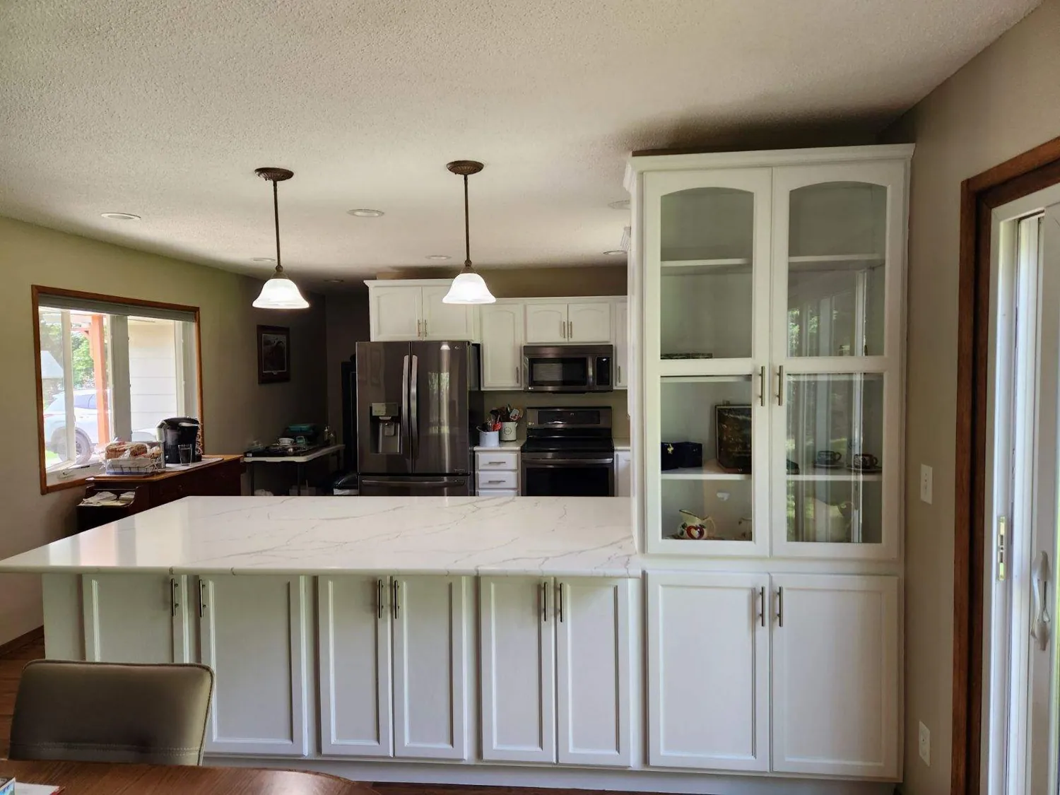 White kitchen with island and glass-front cabinets remodeled in Sioux Falls